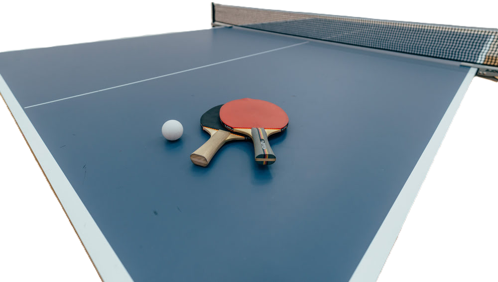 Freigestellte Tischtennisplatte mit zwei Schlägern und einem ball darauf.