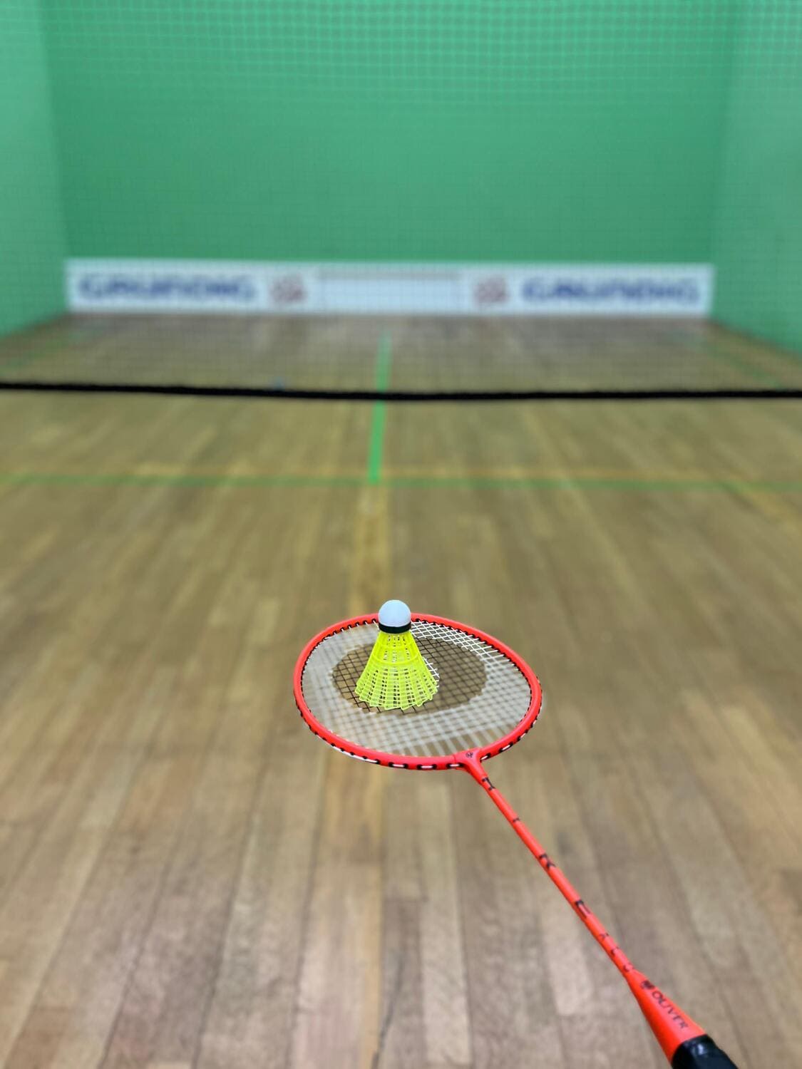 Badminton-Ball liegt auf Badminton-Schläger im Badminton Court des Sportcentrums