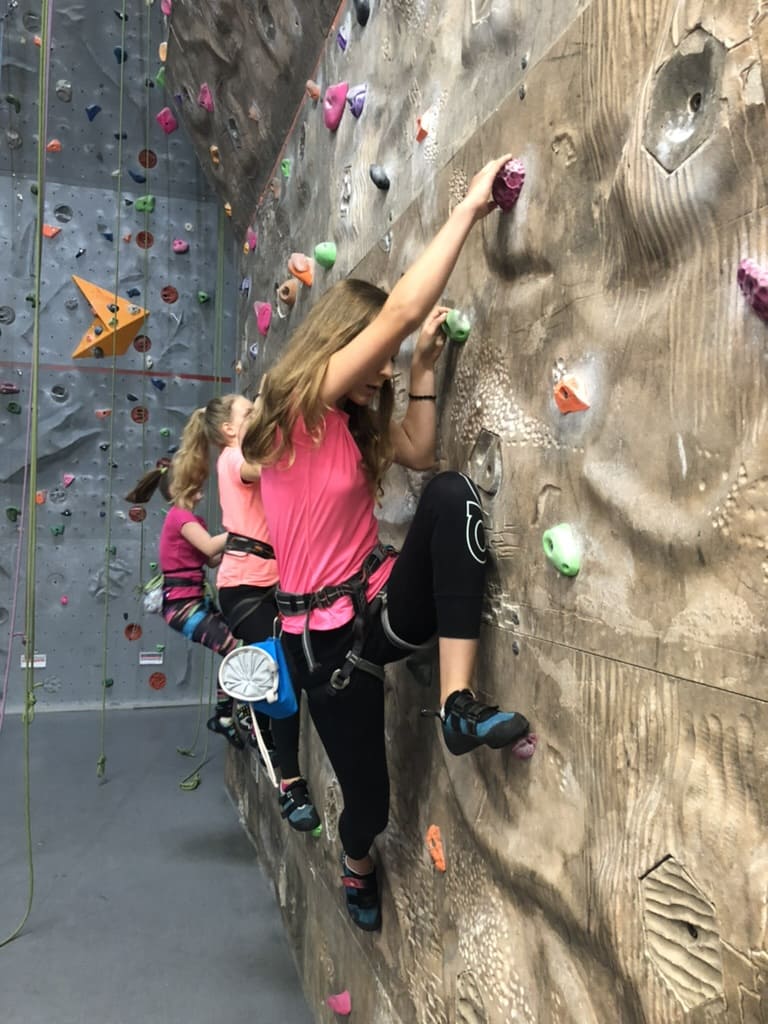 Mehrere Mädchen klettern nebeneinander an der Kletterwand im Sportcentrum Nürnberg
