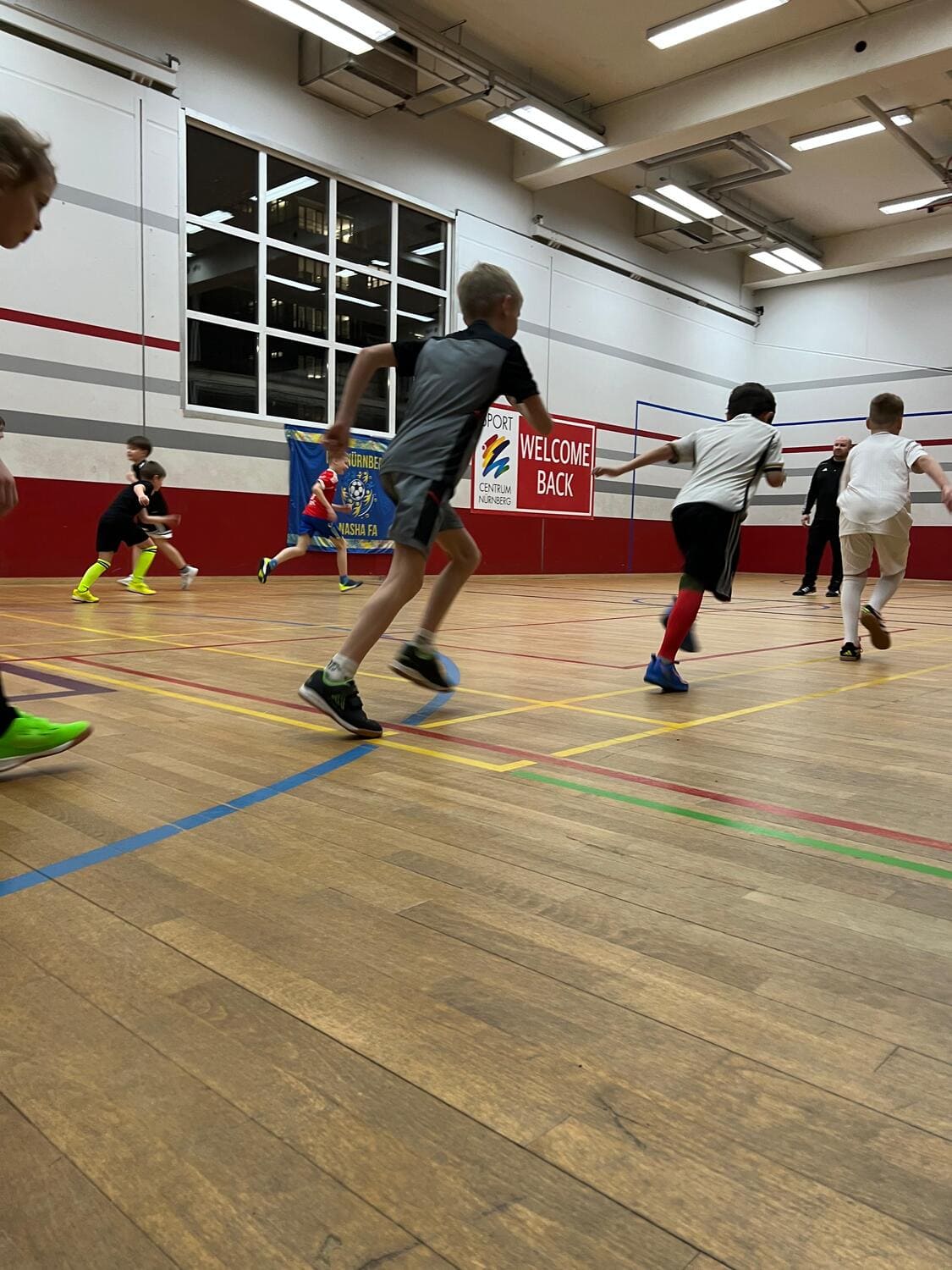 Viele Kinder rennen entlang einer Bodenmarkierung im Game Court des Sportcentrum Nürnberg