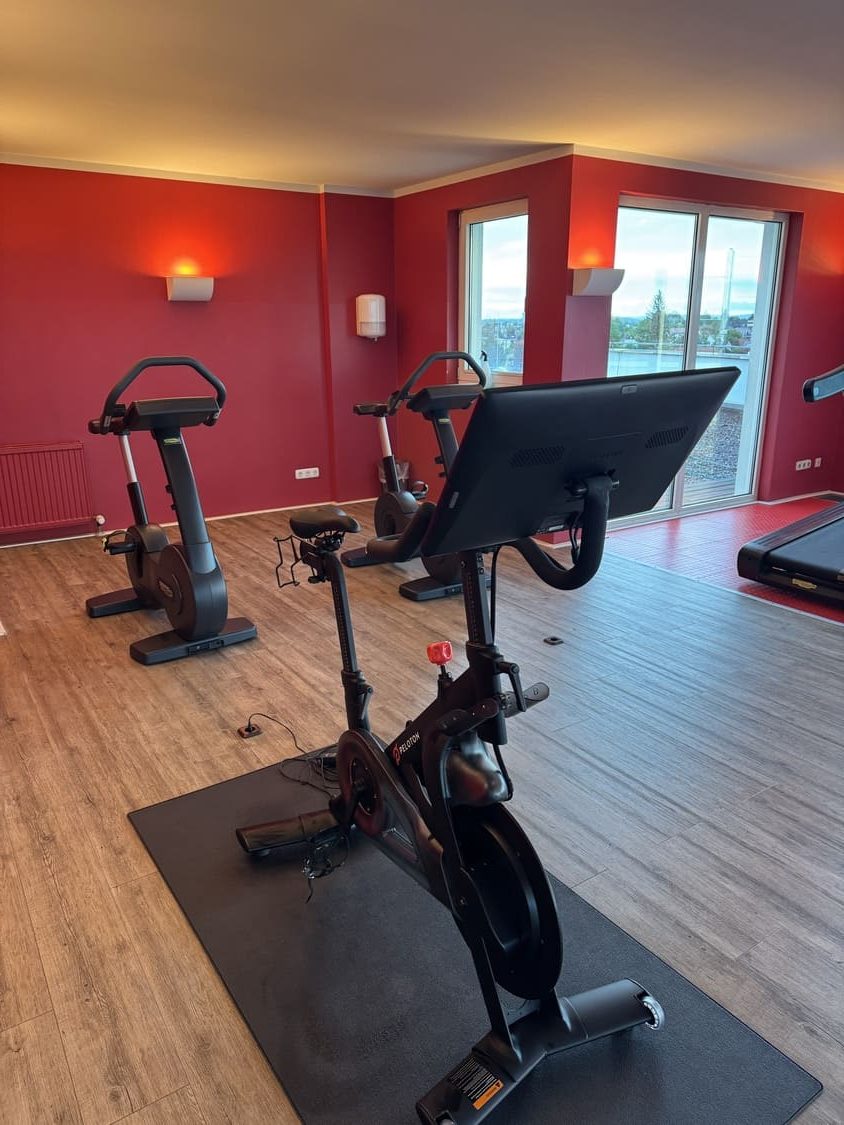 Ein Paleton und zwei Spinning-Fahrräder im Fitnessstudio des Sportcentrum Nürnberg vor einer roten Wand