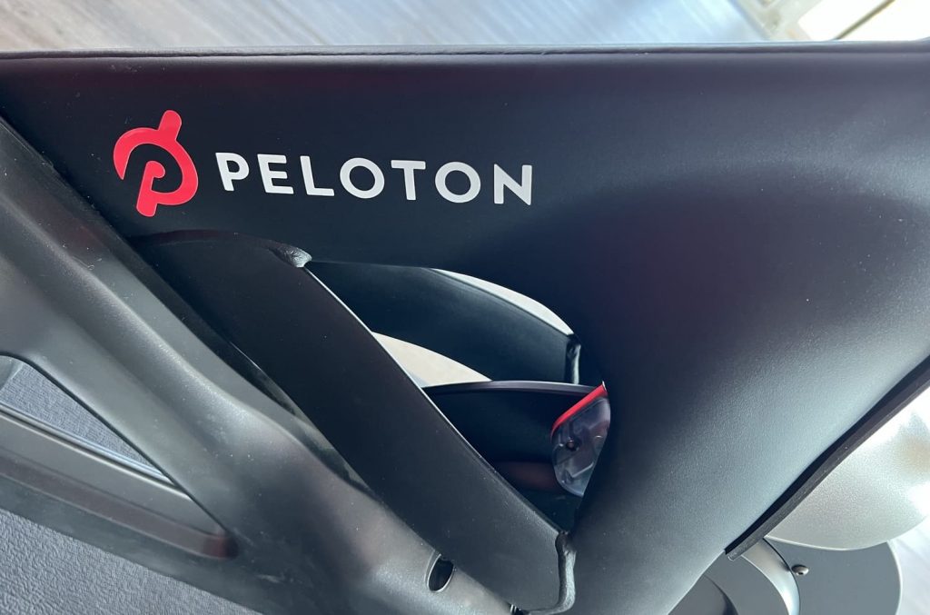 "Peloton"-Aufdruck in Nahaufnahme auf einem Peloton-Fitnessfahrrad