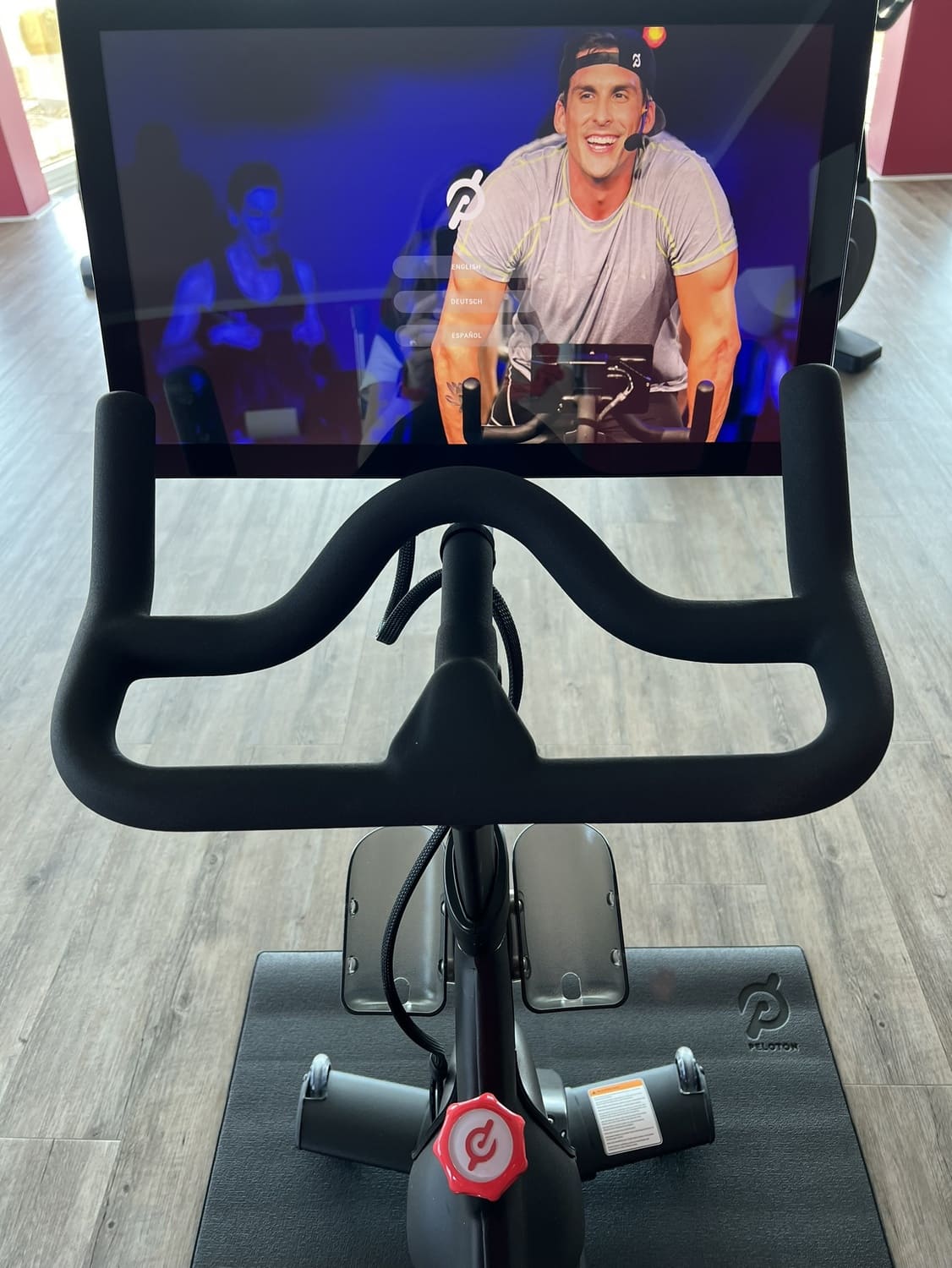 Peloton Fahrrad von Oben mit Blick auf den großen Display, auf dem ein Trainer eine Übung zeigt im Sportcentrum