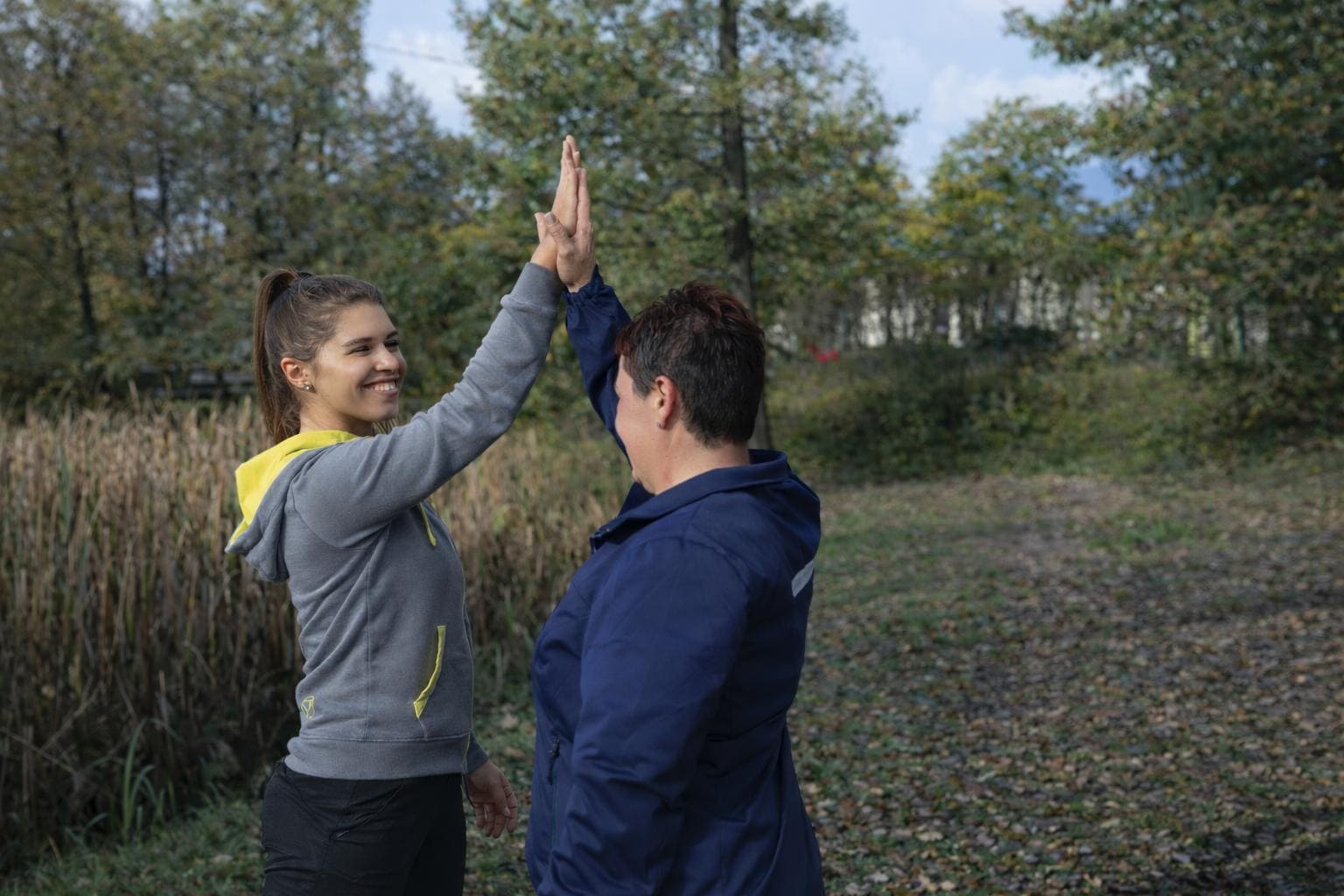 Zwei Frauen klatschen zu einem "High Five" ein und lächeln dabei